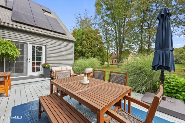 a view of a patio with table and chairs with wooden floor and fence