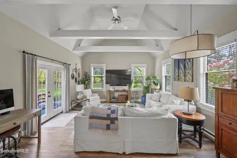 a living room with furniture a flat screen tv and a large window