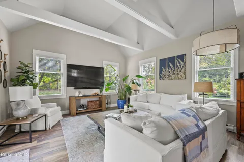 a living room with furniture a flat screen tv and a large window