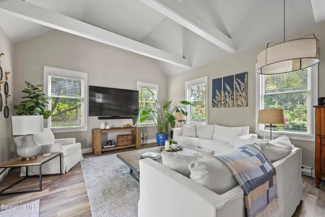 a living room with furniture a flat screen tv and a large window