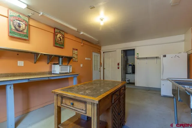 a kitchen with a stove a refrigerator and wooden floor