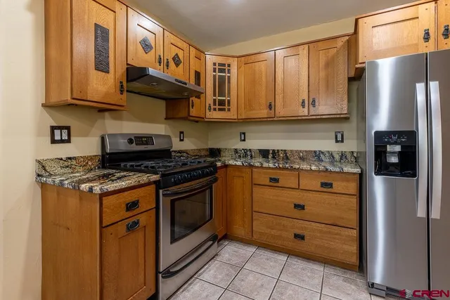 a kitchen with stainless steel appliances granite countertop a stove and a refrigerator