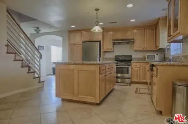 a kitchen with stainless steel appliances granite countertop a sink a stove and a refrigerator
