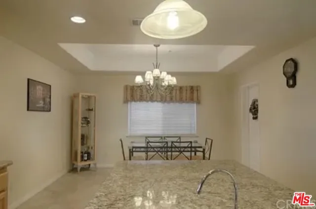 a view of a room with a chandelier furniture and windows