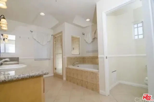 a spacious bathroom with a granite countertop tub sink and mirror