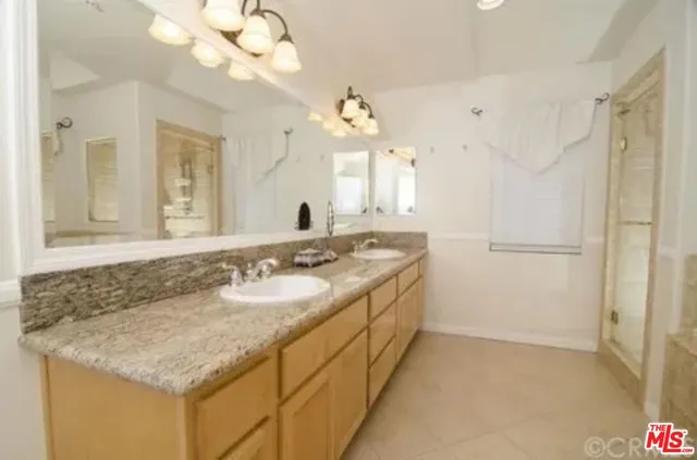 a bathroom with a sink vanity granite and a mirror