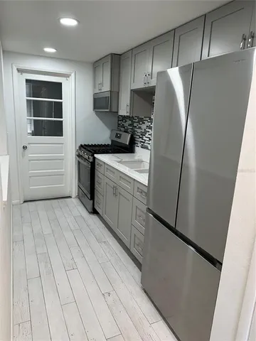a kitchen with stainless steel appliances a refrigerator sink and cabinets