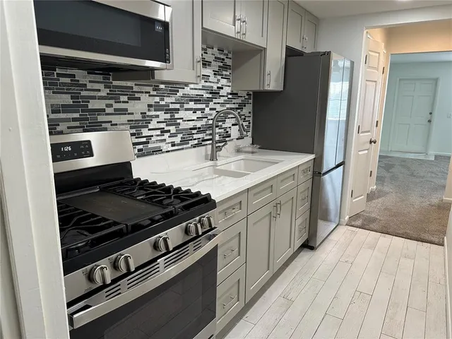 a kitchen with stainless steel appliances a refrigerator and a stove