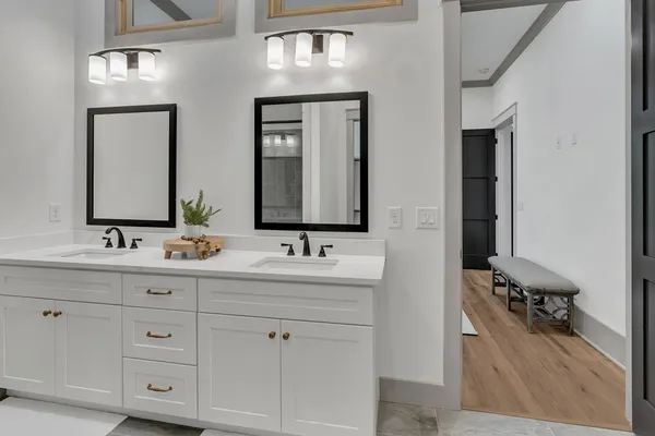 a bathroom with double vanity sinks and a mirror