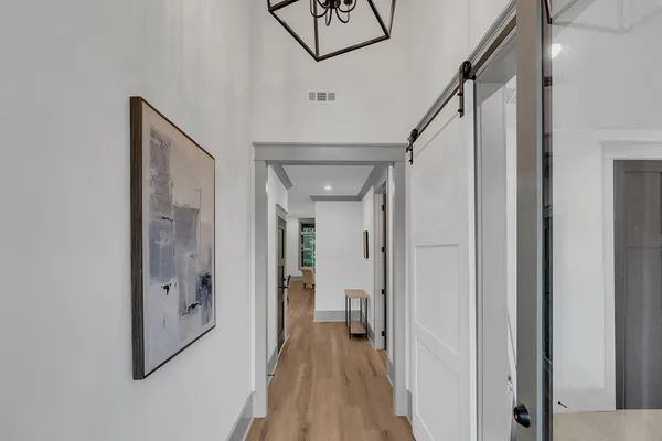a view of a hallway with wooden floor and staircase
