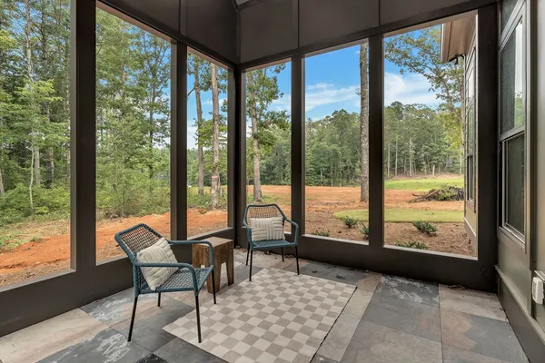 a living room with large windows and a table