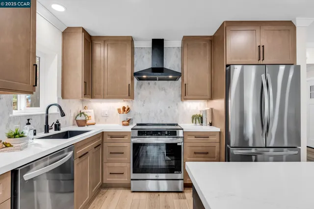 a kitchen with stainless steel appliances a stove sink and refrigerator