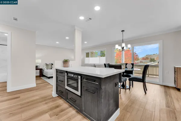 a kitchen with stainless steel appliances a table chairs and a chandelier