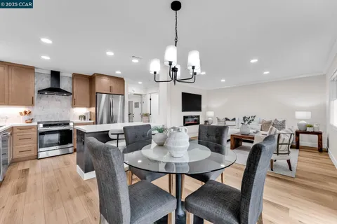 a view of a dining room and livingroom with furniture wooden floor a chandelier