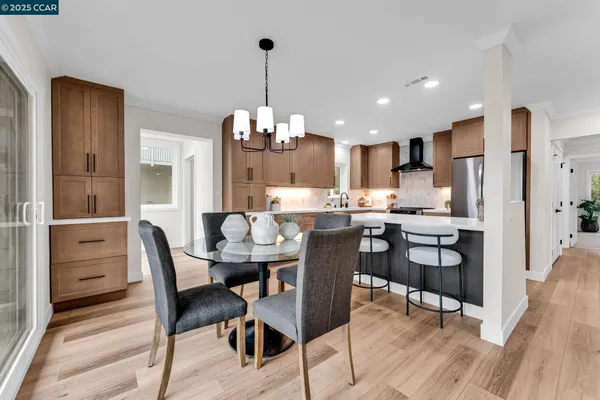 a view of a dining room and livingroom with furniture wooden floor a chandelier