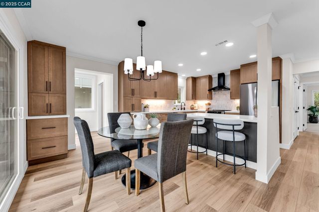 a view of a dining room and livingroom with furniture wooden floor a chandelier