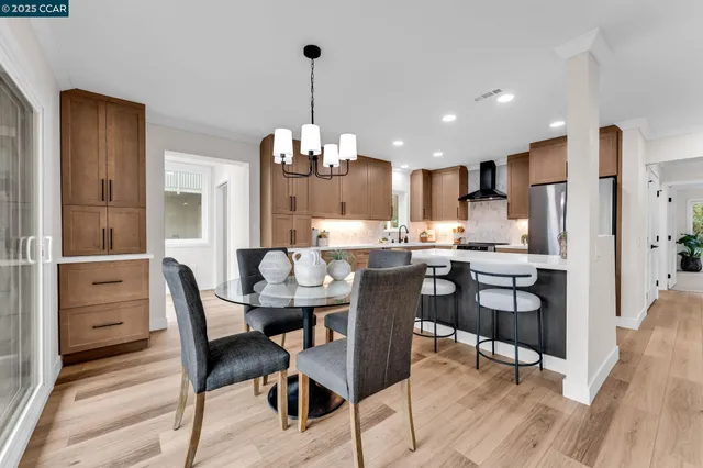 a view of a dining room and livingroom with furniture wooden floor a chandelier