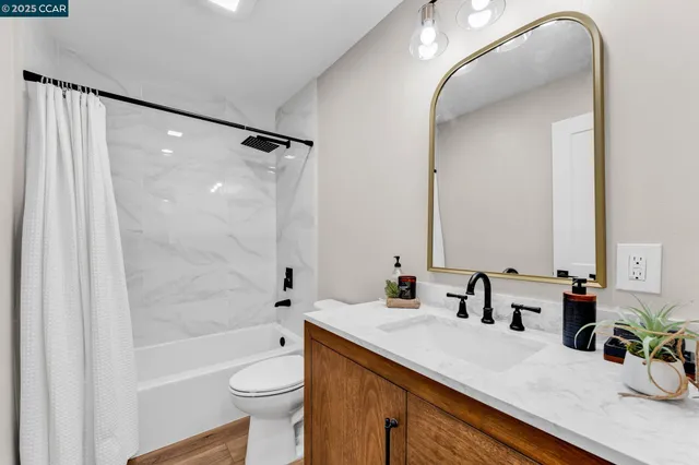 a bathroom with a granite countertop sink toilet and shower