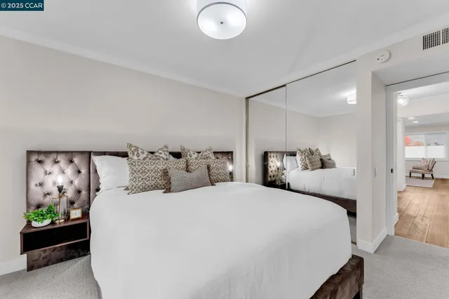 a bedroom with bed and a painting on the wall