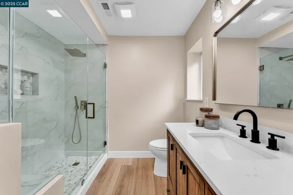 a bathroom with a sink a toilet and shower