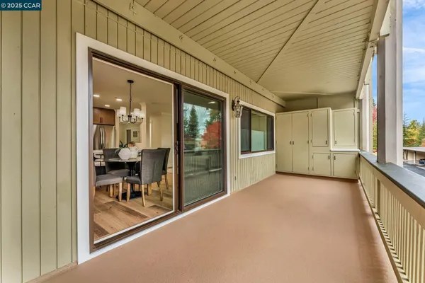 a view of a porch with chairs and floor to ceiling window