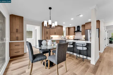 a view of a dining room and livingroom with furniture wooden floor a chandelier