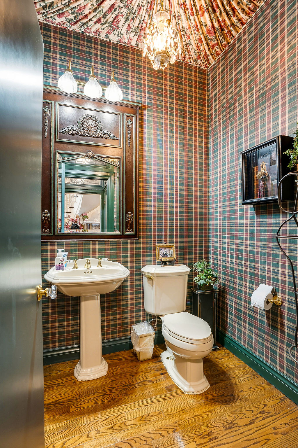 1009 Southeast County Road Ada, OK 74820 - Photo 14 of 92 Pedestal sink, wood-finish flooring, decorative mirror with sconce lighting, and a patterned wallpaper