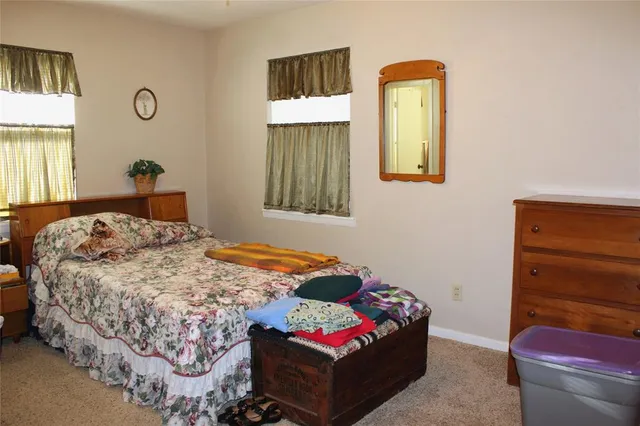 a bedroom with a bed and a dresser next to a window