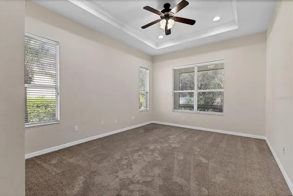 an empty room with a window and a ceiling fan