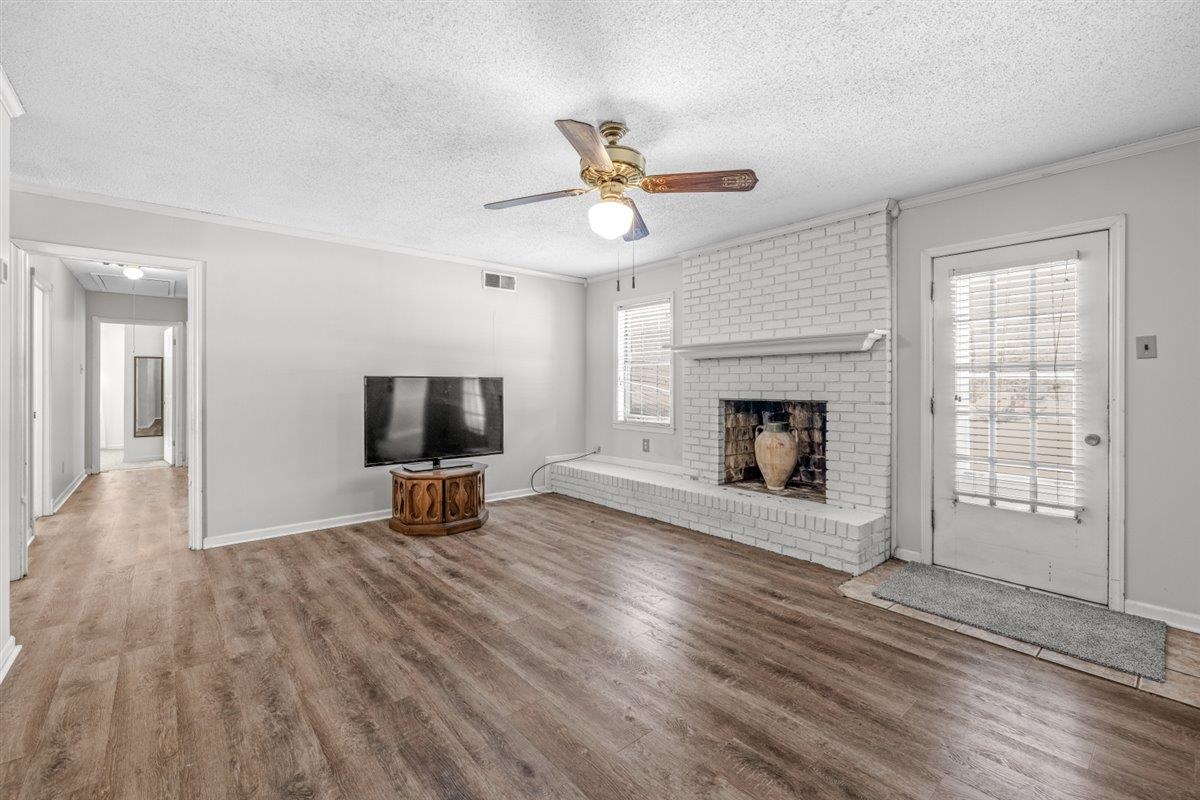 436 Sterling Drive Collierville, TN 38017 - Photo 21 of 40 Unfurnished living room featuring ornamental molding, attic access, ceiling fan, a textured ceiling, and wood finished floors