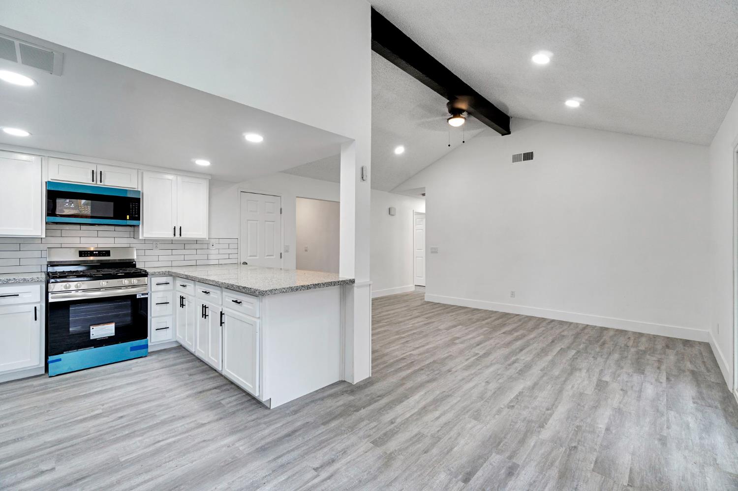 2808 Riverview Drive Madera, CA 93637 - Photo 14 of 35 kitchen featuring gas stove, a peninsula, white cabinetry, tasteful backsplash, and ceiling fan