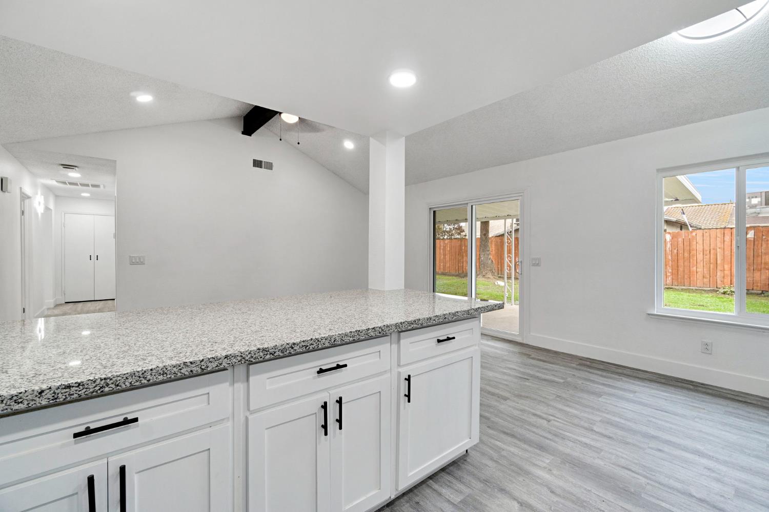 2808 Riverview Drive Madera, CA 93637 - Photo 18 of 35 kitchen with light stone counters, white cabinets, a textured ceiling, light wood-style flooring, and recessed lighting