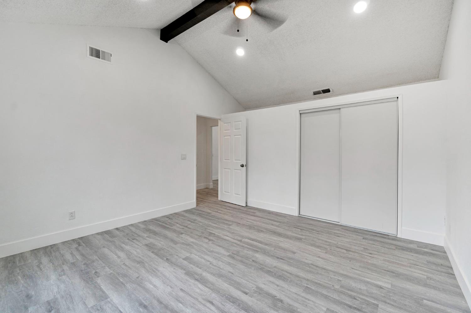 2808 Riverview Drive Madera, CA 93637 - Photo 20 of 35 unfurnished bedroom featuring beam ceiling, light wood-type flooring, a closet, a textured ceiling, and high vaulted ceiling