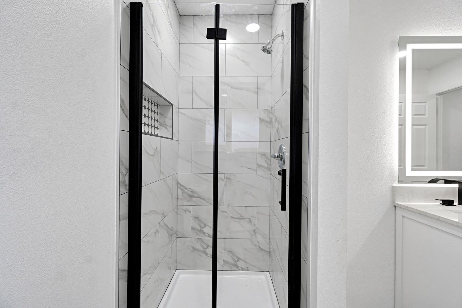 2808 Riverview Drive Madera, CA 93637 - Photo 31 of 35 bathroom featuring a textured wall, a marble finish shower, and vanity