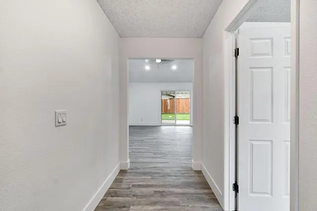 a view of a hallway with wooden floor