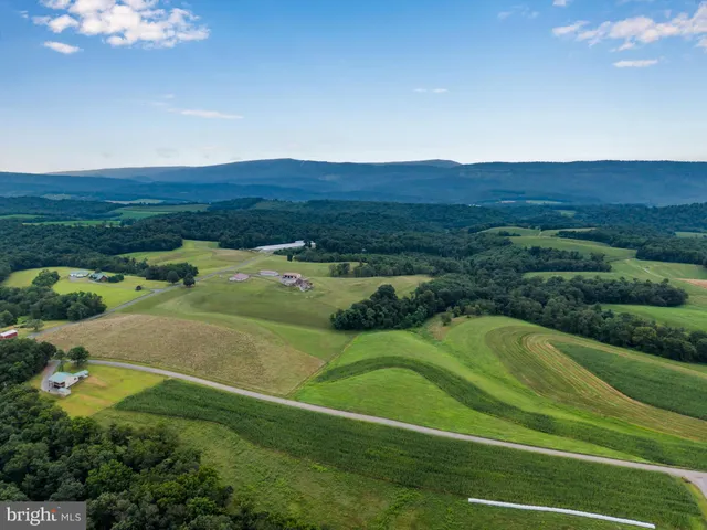 a large kitchen with stainless steel appliances kitchen island granite countertop a refrigerator a oven and a stove with wooden floor