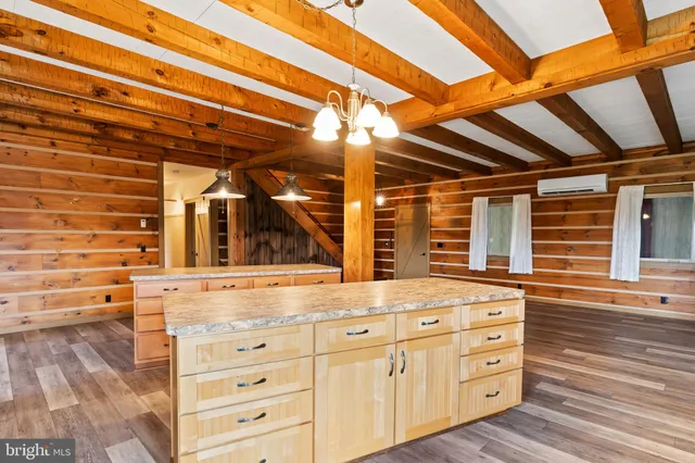 a view of kitchen with stainless steel appliances wooden floor and chandelier