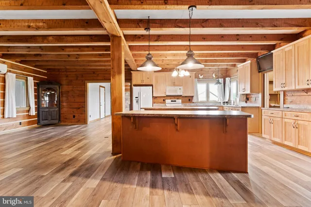 a view of an empty room with wooden floor fireplace and a window