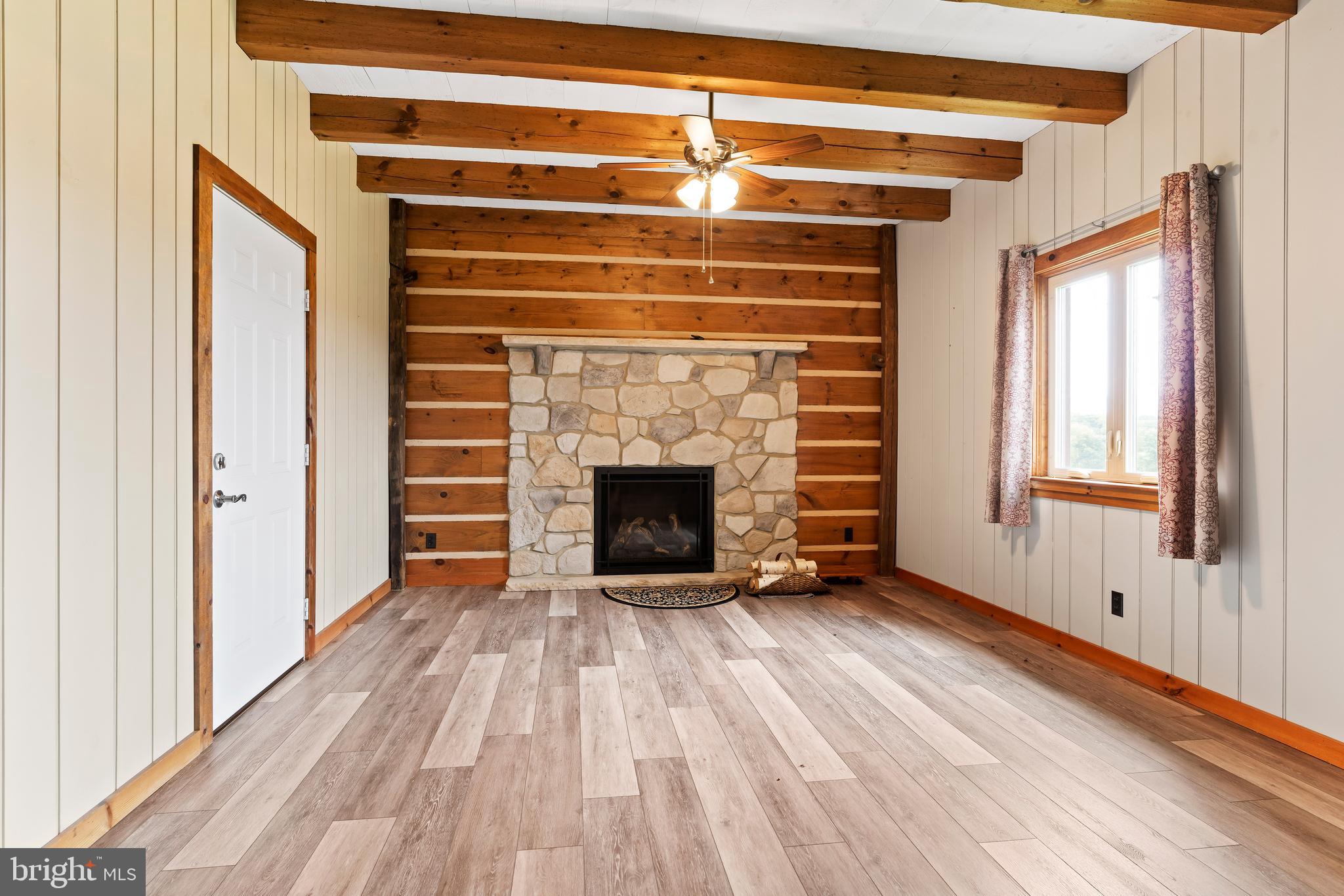 729 Gloss Road East Waterford, PA 17021 - Photo 30 of 70 a view of an empty room with wooden floor fireplace and a window