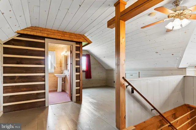a view of a hallway with furniture and a chandelier