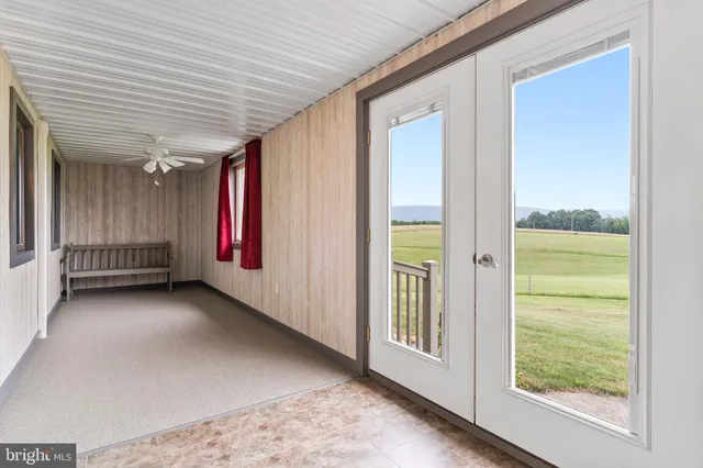 a view of an empty room with wooden floor and fence