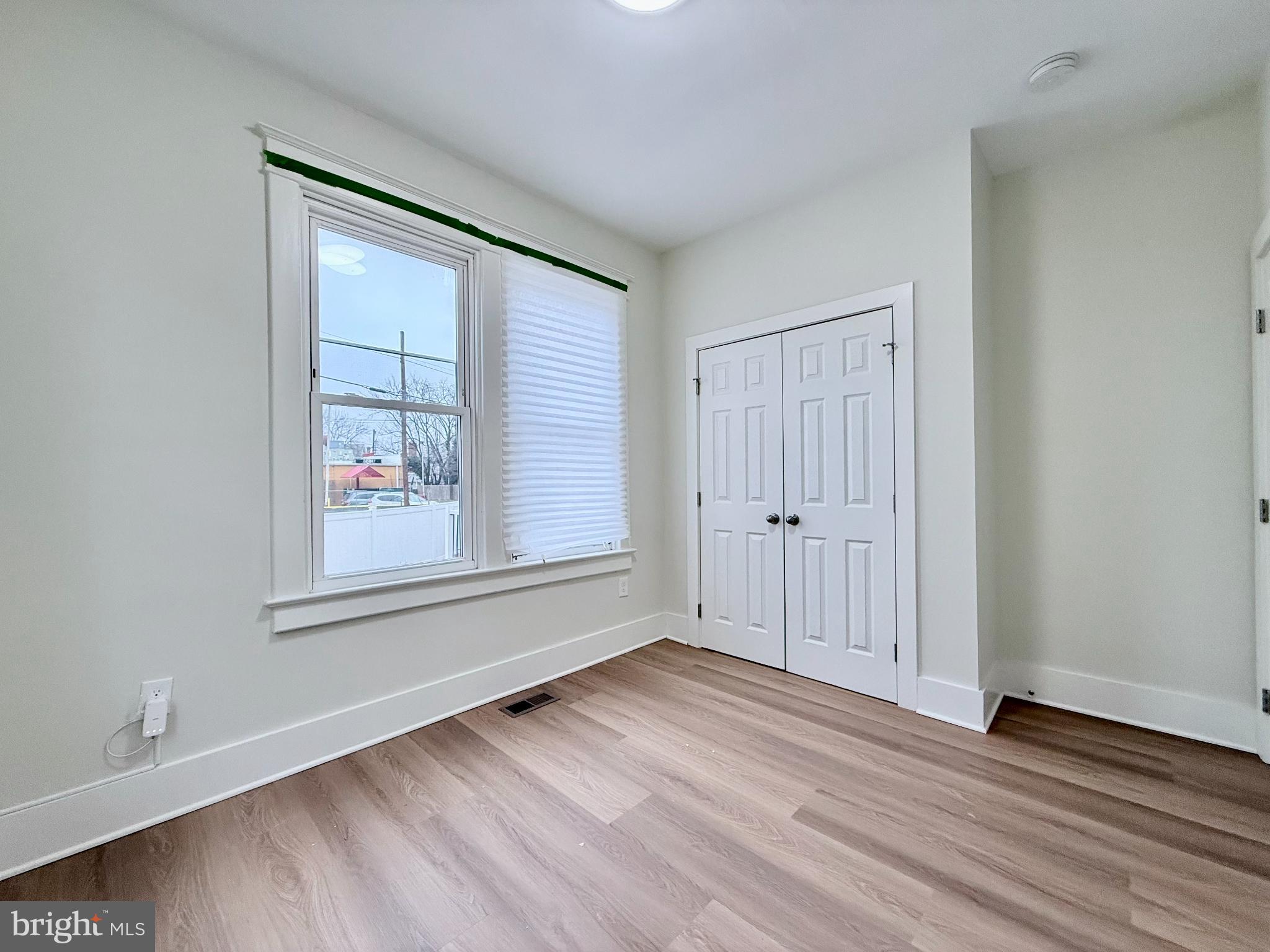 610 Raleigh Place Southeast Washington, DC 20032 - Photo 11 of 15 a view of an empty room with wooden floor and a window