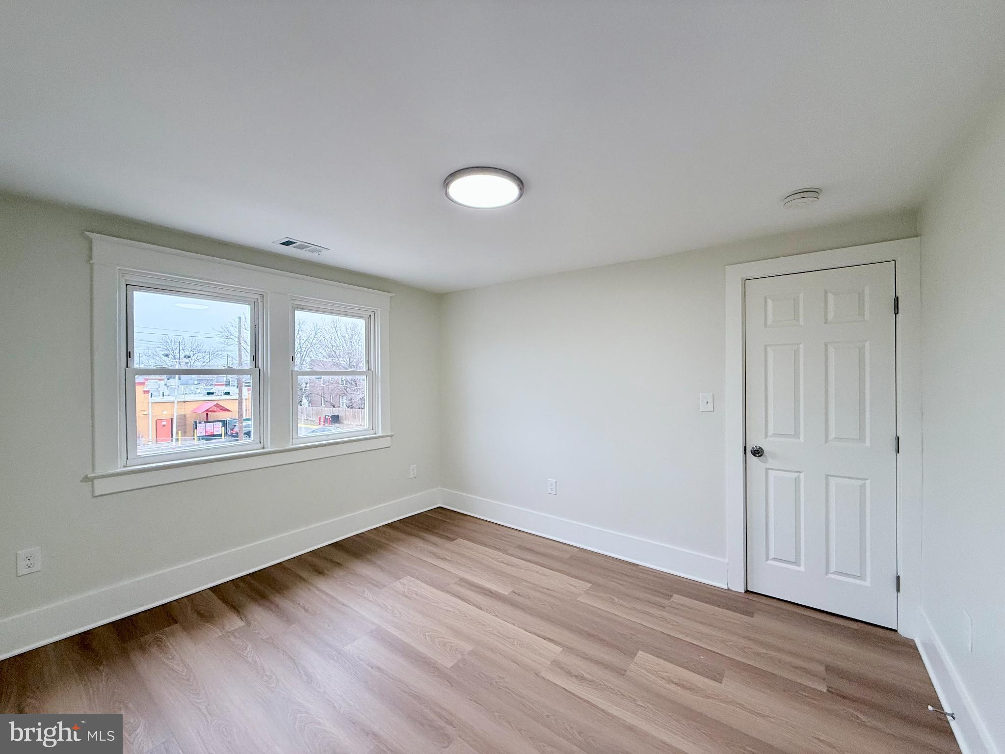 610 Raleigh Place Southeast Washington, DC 20032 - Photo 15 of 15 a view of an empty room with wooden floor and a window