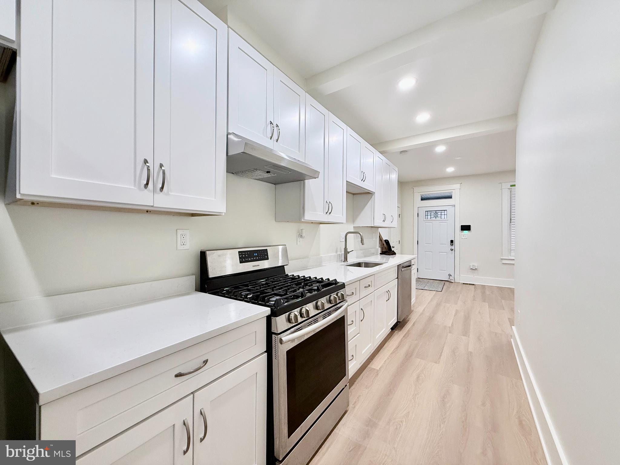 610 Raleigh Place Southeast Washington, DC 20032 - Photo 2 of 15 a kitchen with granite countertop a stove top oven a sink a counter space and cabinets