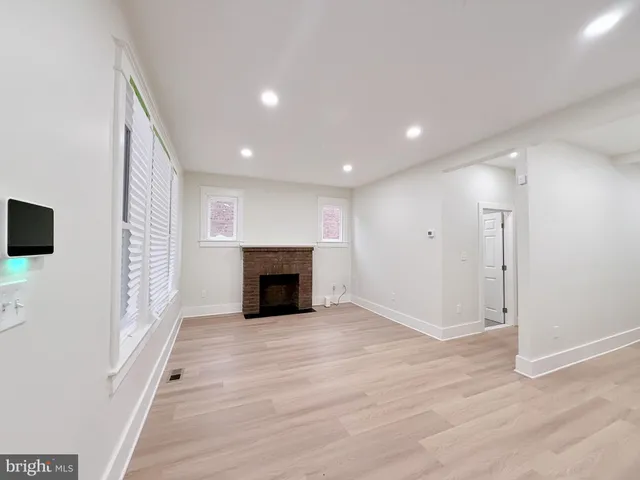 a view of empty room with wooden floor and fireplace