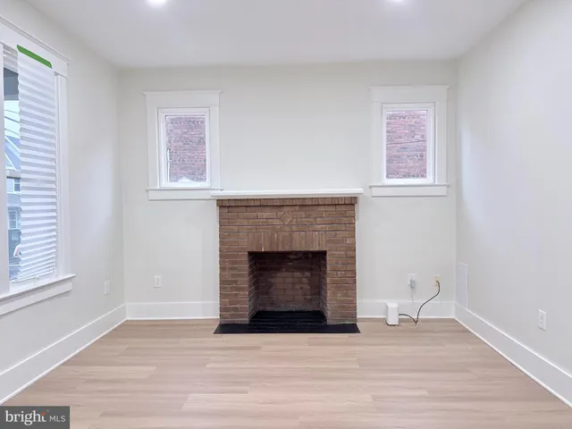 a living room with a fireplace and a wooden floor