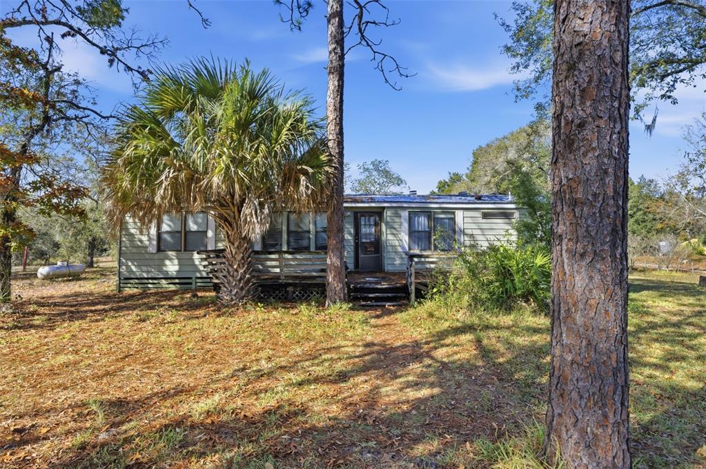 8045 Indian Trail Road Weeki Wachee, FL 34613 - Photo 40 of 49 a backyard of a house with yard and outdoor seating