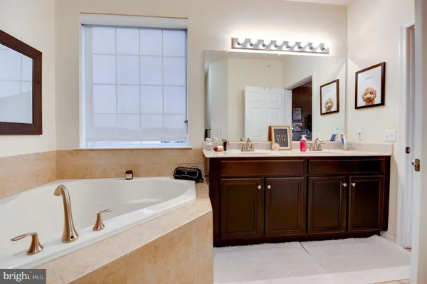 a bathroom with a tub sink and mirror