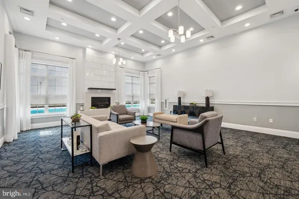 a living room with furniture a fireplace and a chandelier