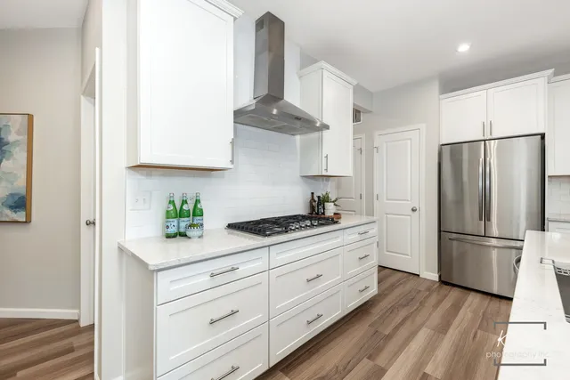 a kitchen with stainless steel appliances white cabinets and a refrigerator